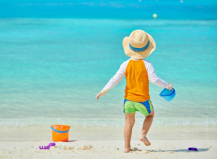 Ein Kind spielt im Sommer am Strand
