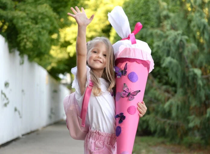 Mädchen hält stolz ihre Schultüte zur Einschulung.